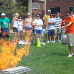students gather around a grassy area outside day hall for fire safety training